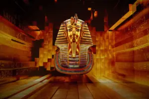 Tutankhamonin-kuolinnaamio Kultainen Tutankhamonin kuolinnaamio leijuu hieroglyfein koristellun käytävän päässä 360°-projisoinnissa
